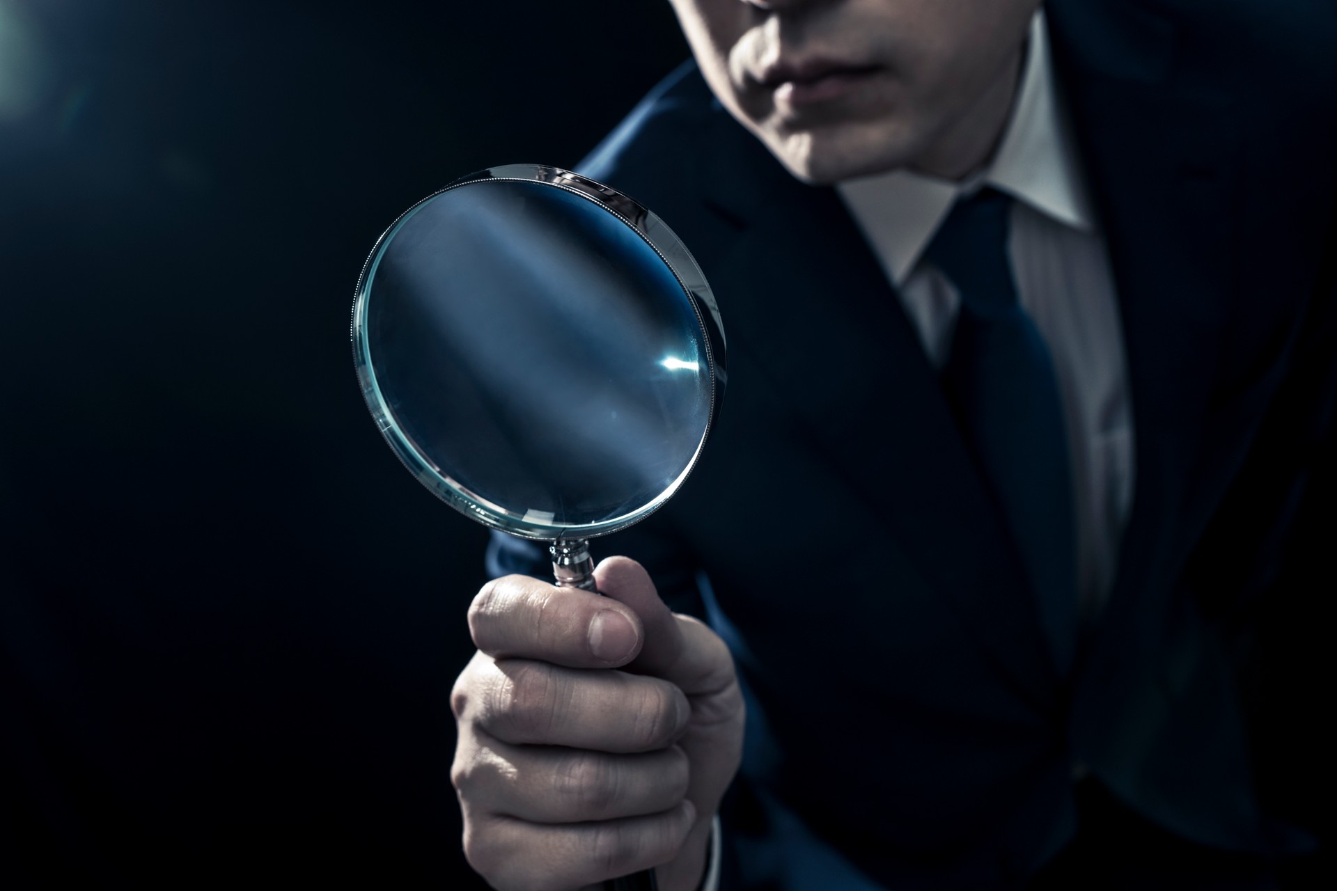 Male Businessman Peering Through Magnifying Glass